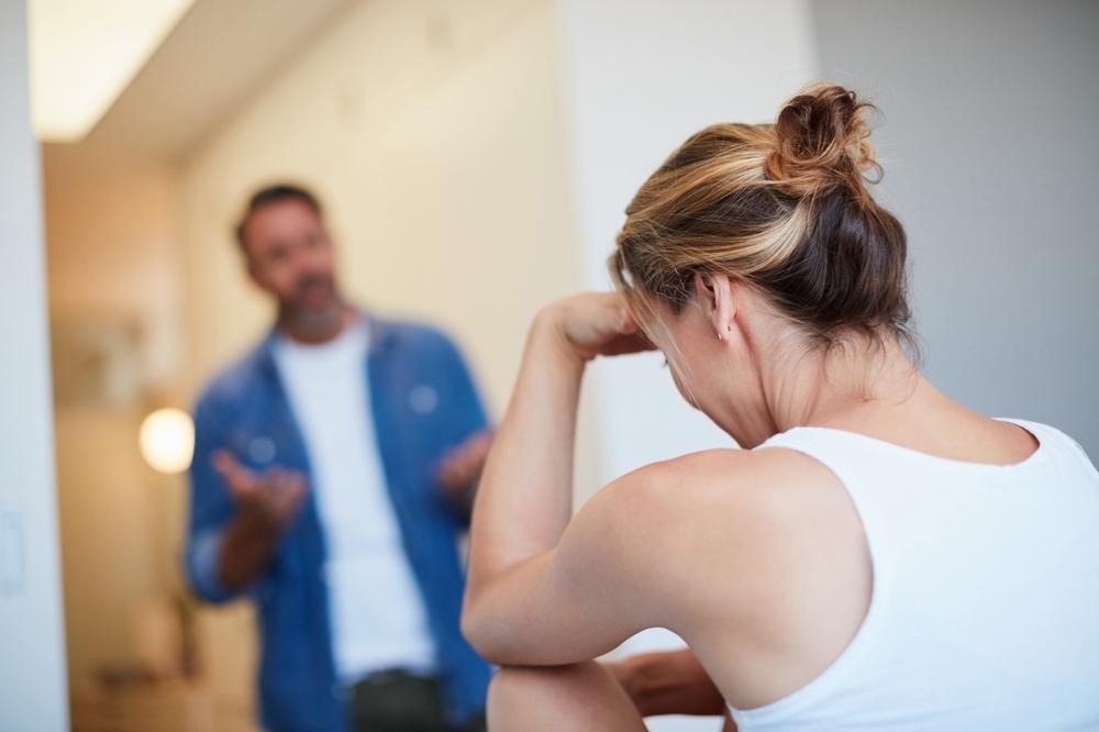 Mulher com a mão sobre a cabeça durante discussão