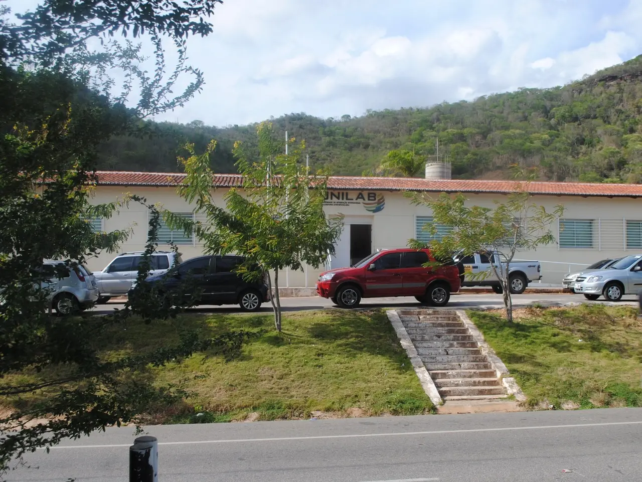 Fachada de um dos prédios da Unilab Ceará, com carros estacionados na frente