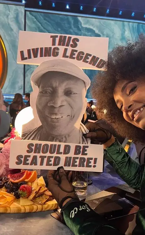 Esperanza Spalding segura cartaz com protesto sobre Milton Nascimento no Grammy 2025. Indicado ao Grammy 2025, Milton Nascimento não senta com demais concorrentes no evento