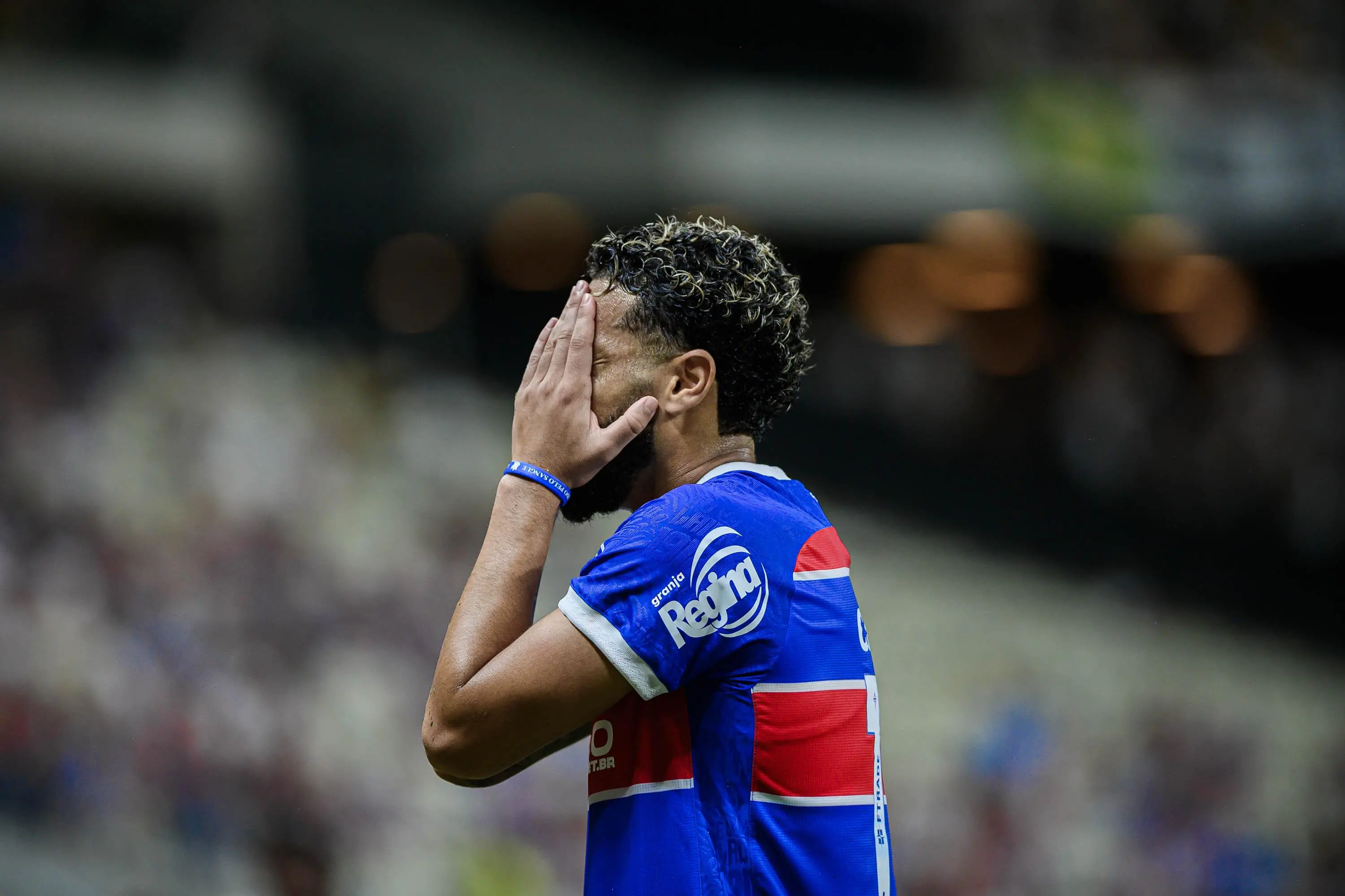 Foto de Calebe, jogador do Fortaleza, lamentando com a mão no rosto em jogo