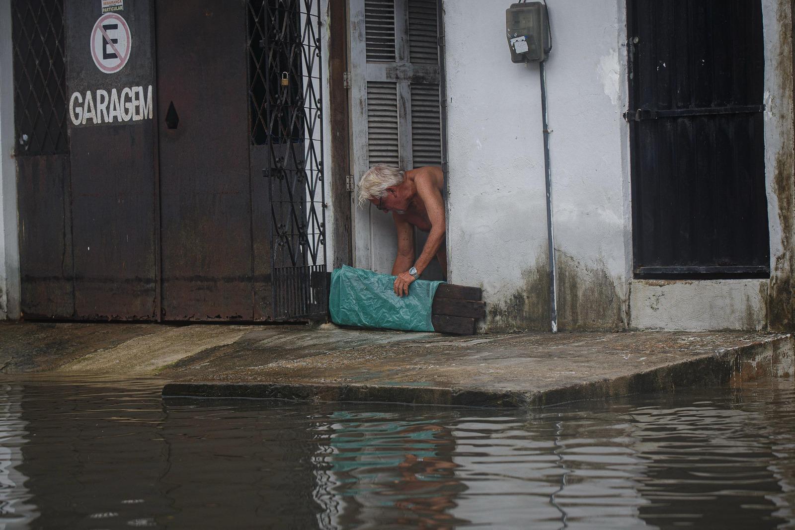 Homem coloca tábua para barrar água
