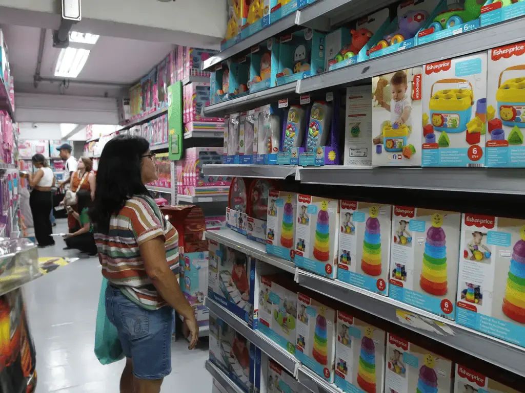 a imagem mostra mulher em frente a prateleiras de produtos infantis na semana do consumidor