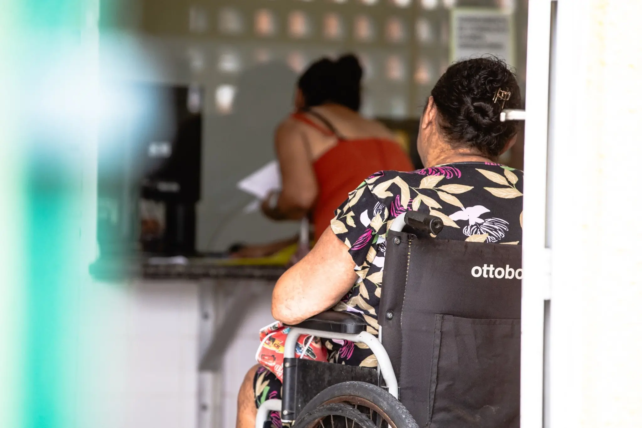 Paciente de costas, sentada em cadeira de rodas