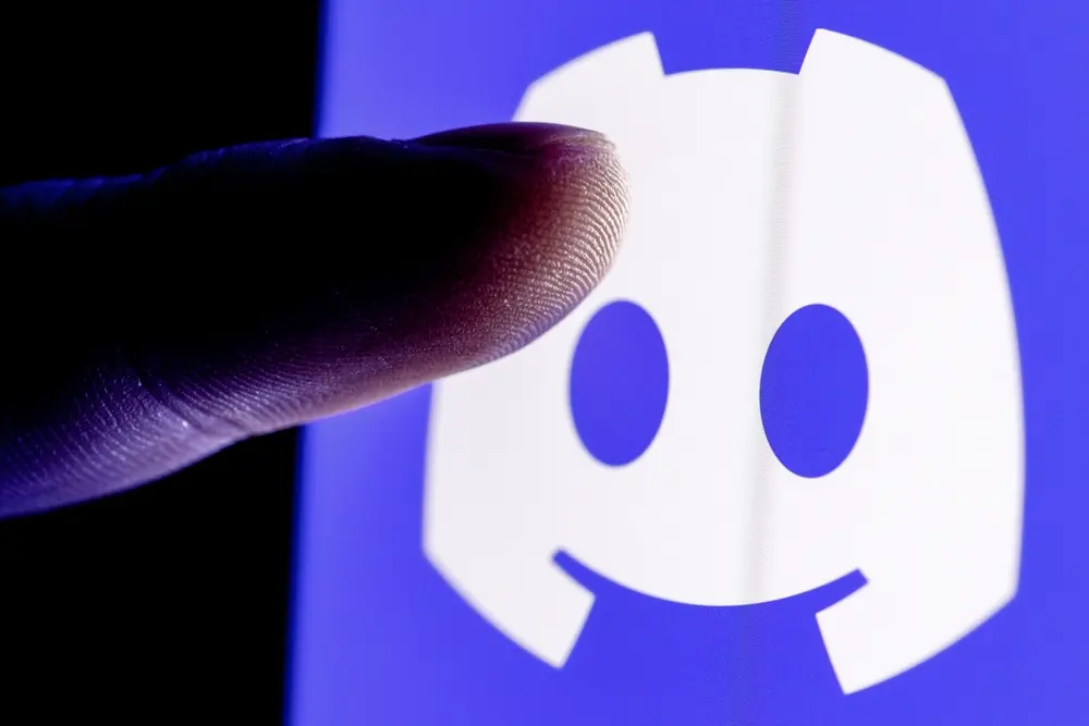 Dedo se aproximando da tela do celular para clicar no ícone do aplicativo do Discord para matéria informando sobre investigação da polícia civil sobre suposta apologia à violência digital