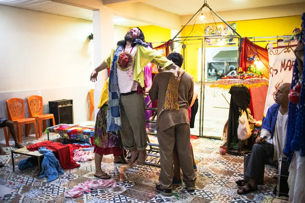 Em Às Margens, a cruz de madeira dá lugar a um carrinho utilizado por catadores de material reciclável