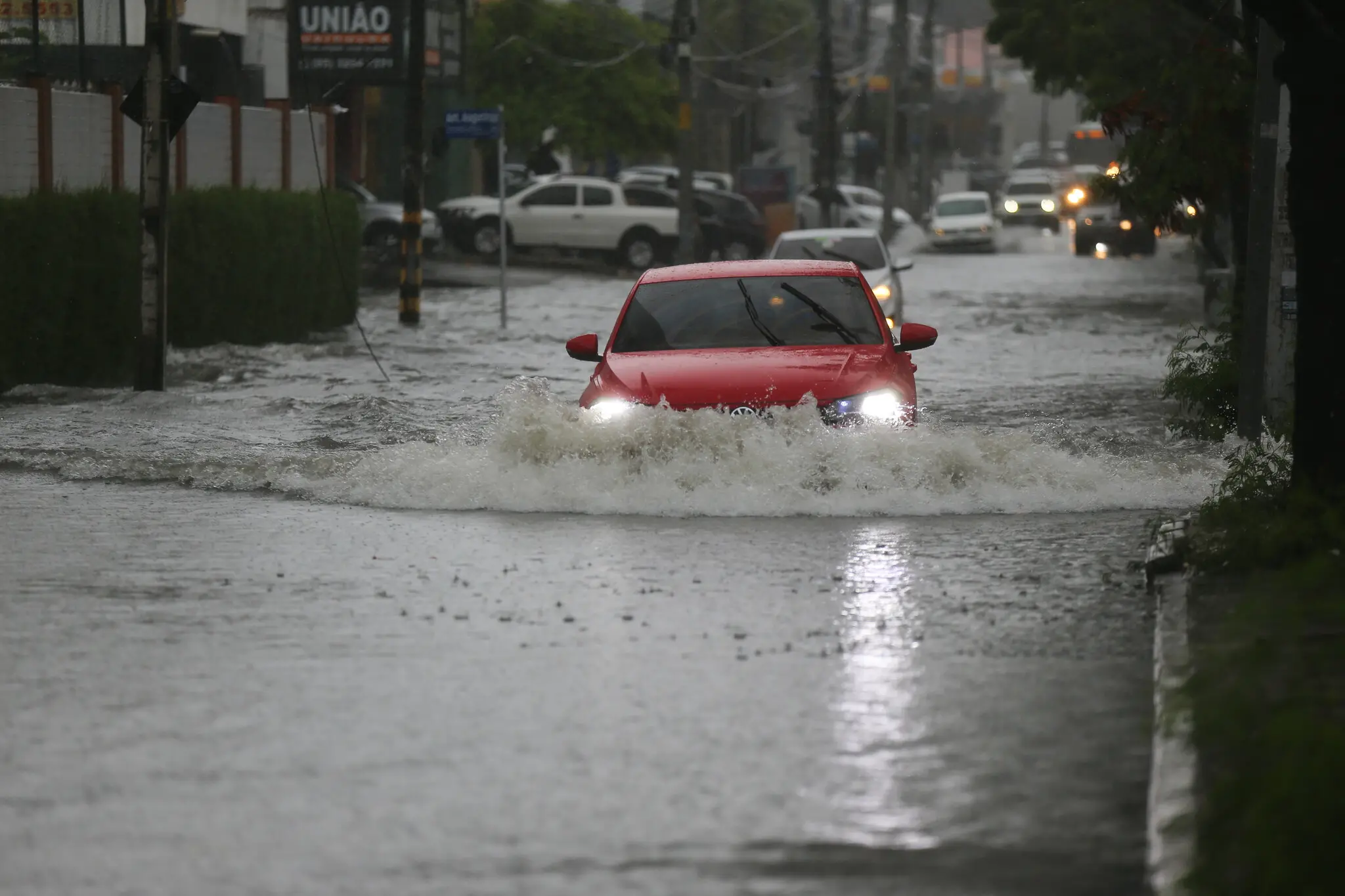Carro submerso em alagamento em avenida de Fortaleza