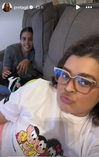 Preta Gil e amiga no sofá de casa, após ter alta de internação em hospital de São Paulo
