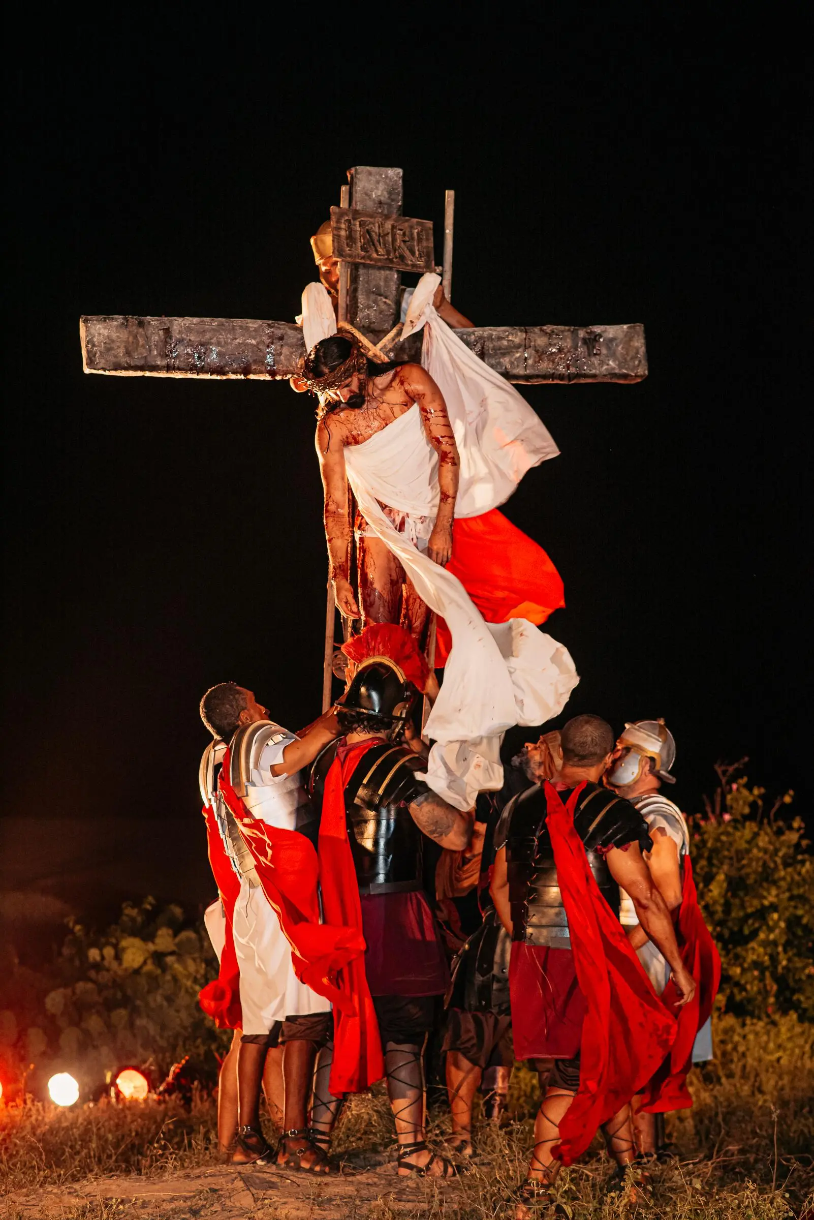 Momento da crucificação representado ao ar livre com o ator que interpreta Jesus pendurado na cruz