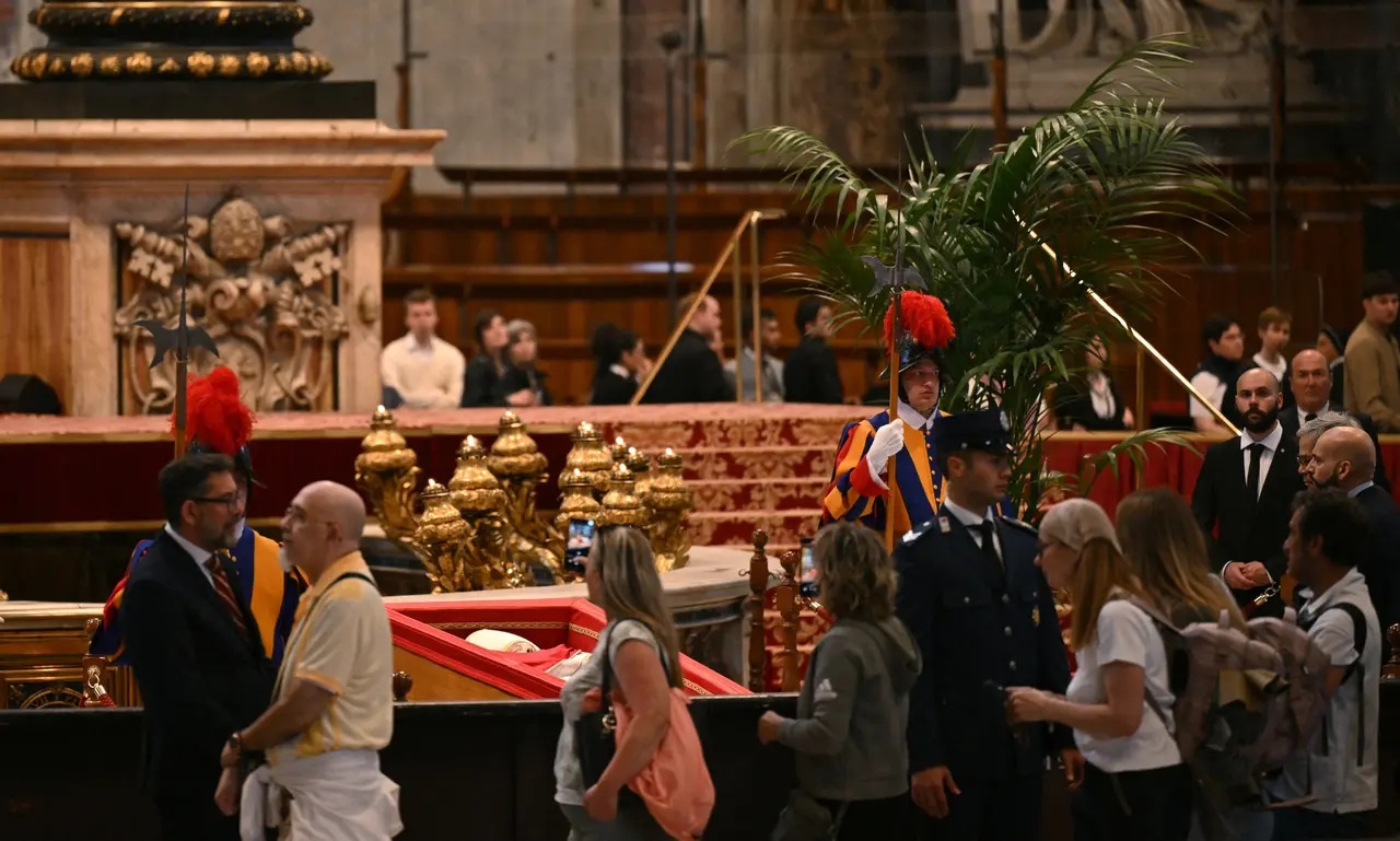 Pessoas passando pelo corpo do papa Francisco