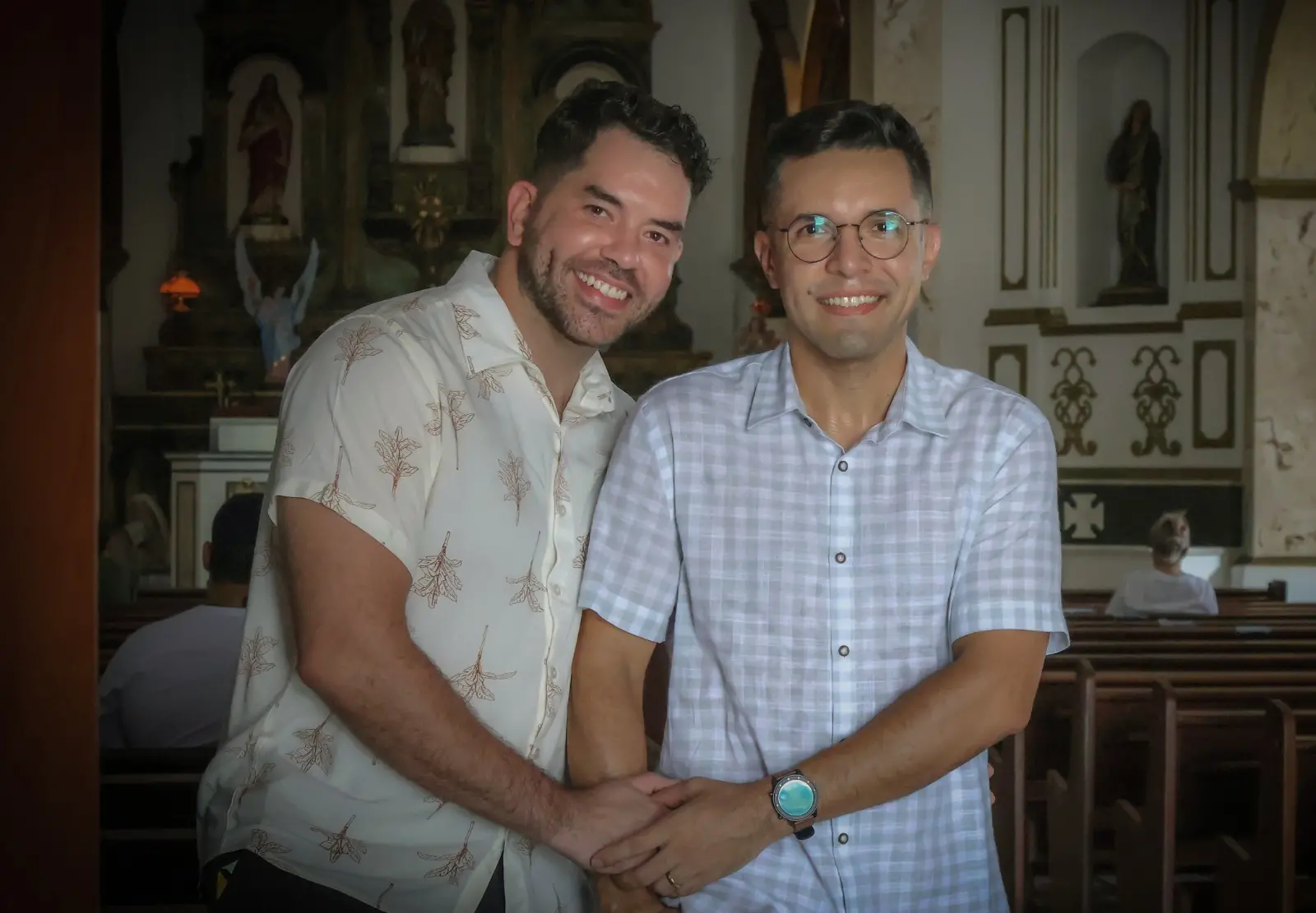 Casal de homens segurando nas mãos dentro da igreja