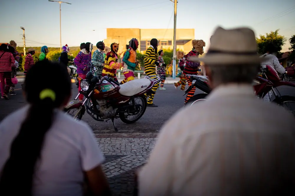 Na imagem, casal observa cortejo dos caretas em Saboeiro