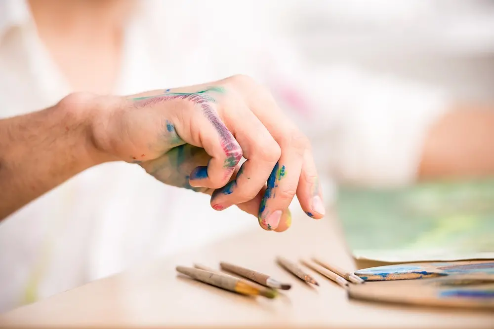 Na imagem, pessoa colorindo superfície