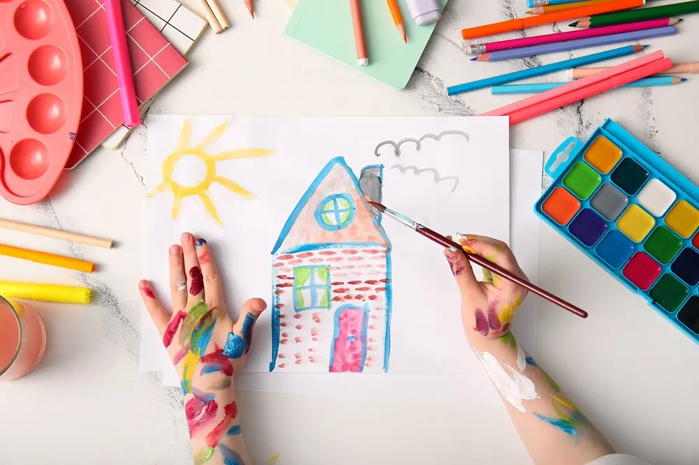 Na imagem, criança pintando livro de colorir