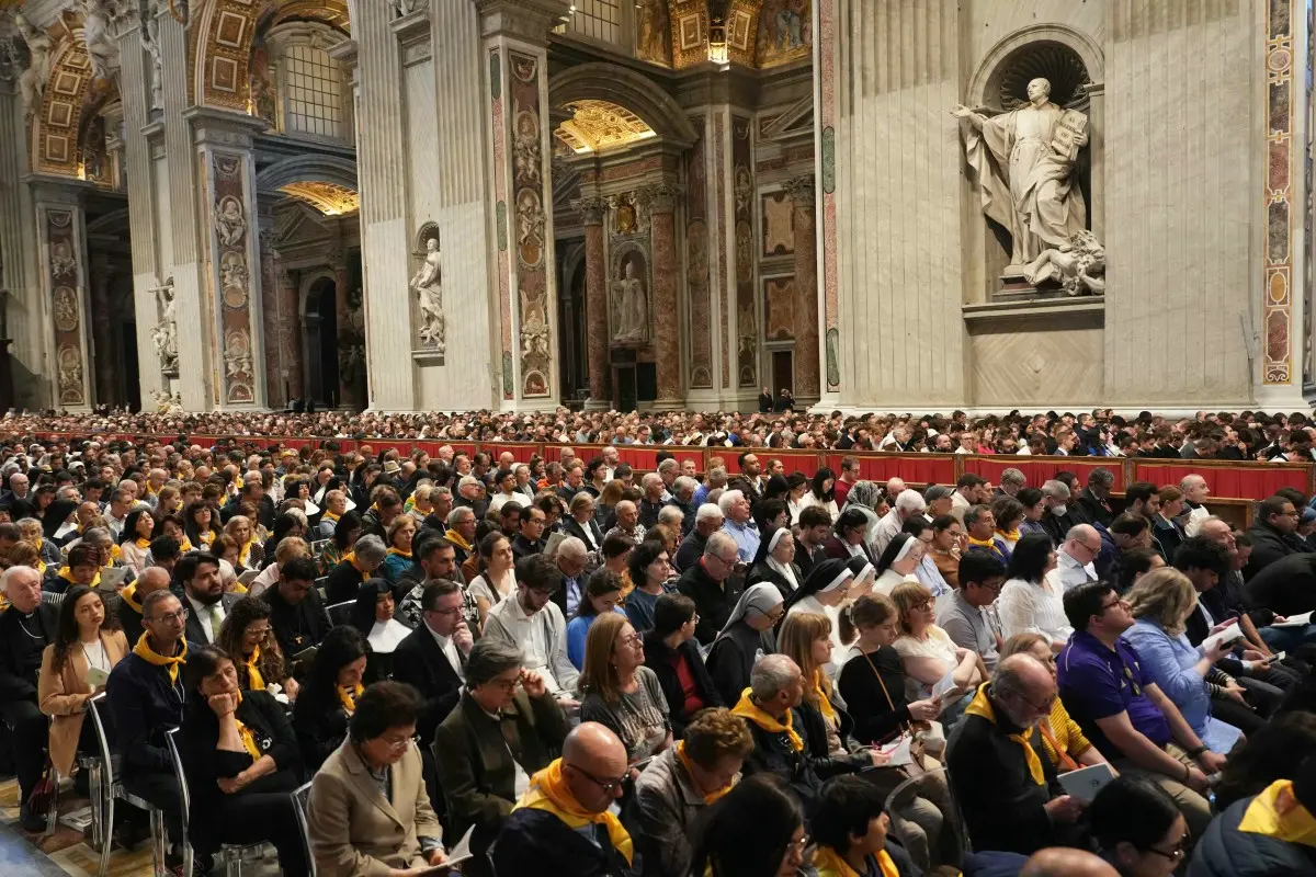 Multidão reunida na Basílica de São Pedro, aguardando um evento religioso em um ambiente majestoso com detalhes arquitetônicos impressionantes.