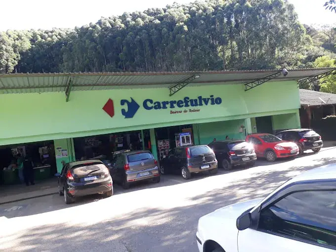 Fachada do supermercado Carrefúlvio, destaque para a sinalização e veículos estacionados na frente