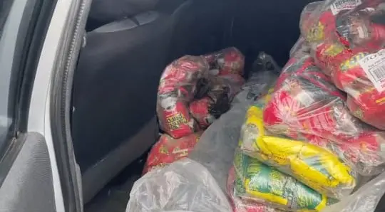 Na imagem o banco de trás de um carro cheio de embalagens de café