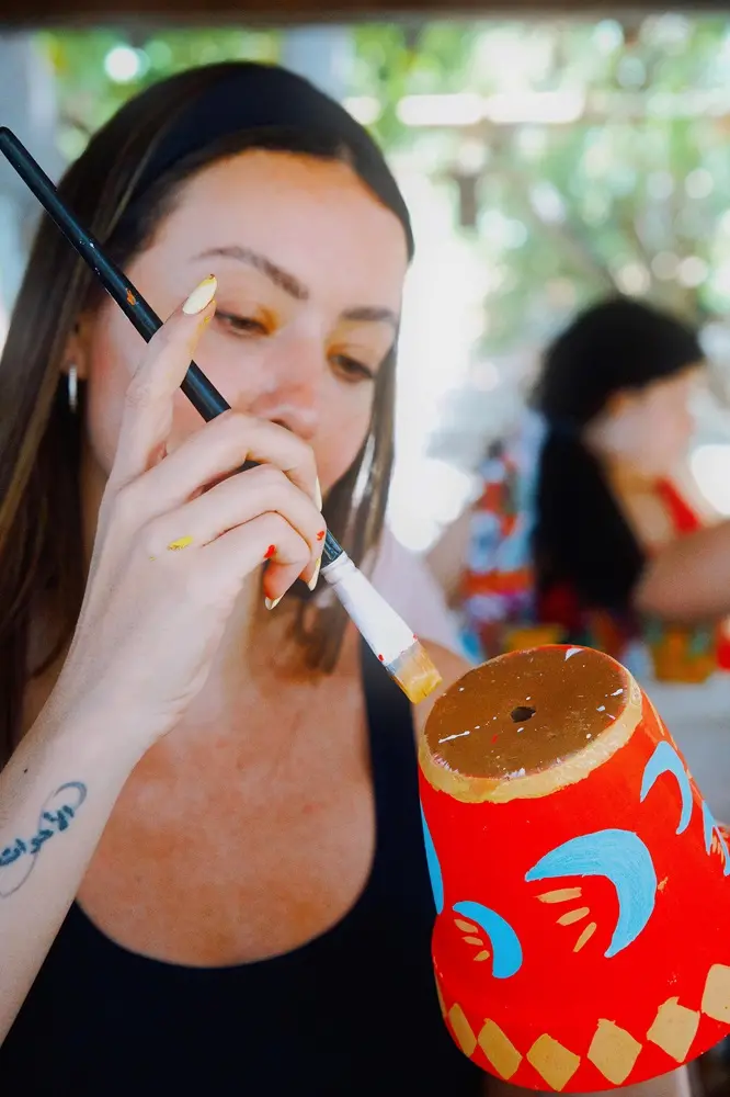 Na imagem, mulher pinta superfície a partir de atividade da empresa Pincelê