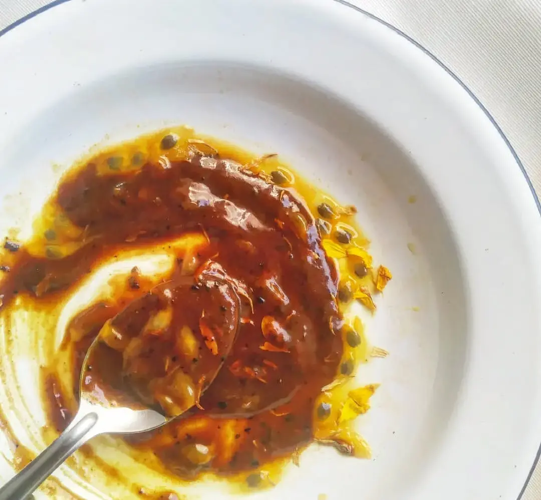 Imagem de doce leite Iyálodê, com maracujá selvagem, casca de laranja, imburana de cheiro e pétalas de calêndula