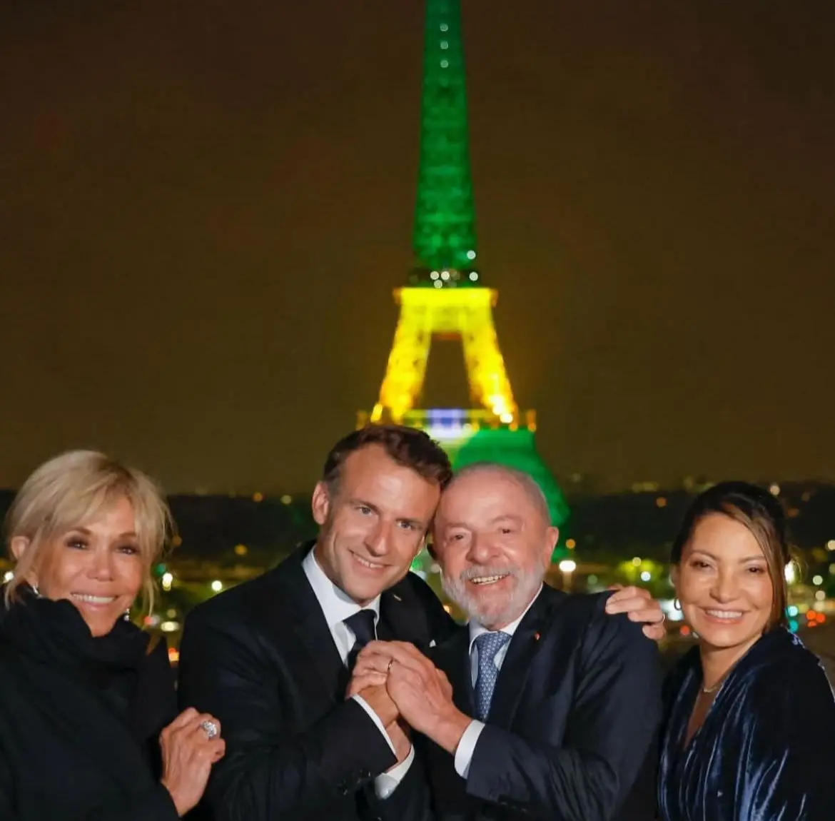 foto de Lula, Emmanuel Macron, Janja da Silva e Brigitte Macron na torre Eiffel iluminada com as cores do Brasil
