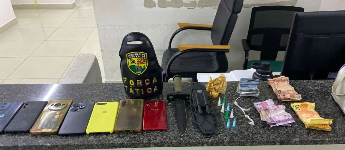 Itens apreendidos pela polícia no boletim de ocorrência, incluindo pneus, armas, dinheiro e drogas, em cenário de investigação policial.