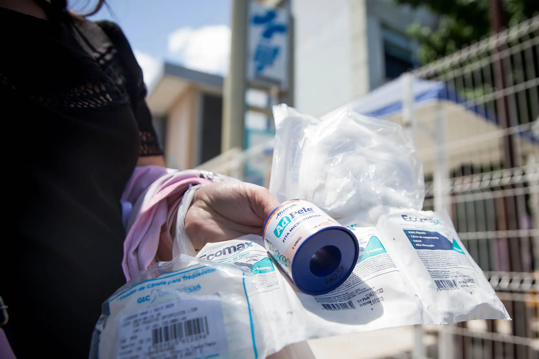 Pessoa em frente ao IJF segurando insumos médicos, em contexto da crise na saúde de Fortaleza
