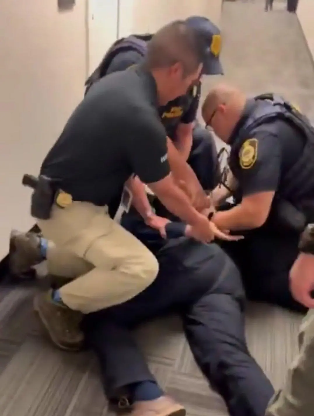 Alex Padilla senador democrata imobilizado no chão e algemado por agentes do FBI