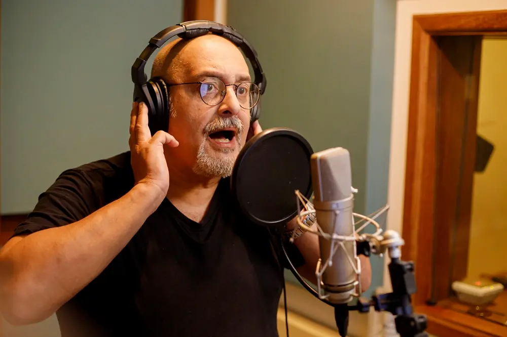 Na imagem, o ator e dublador Mauro Ramos em estúdio da empresa Audible narrando um audiolivro