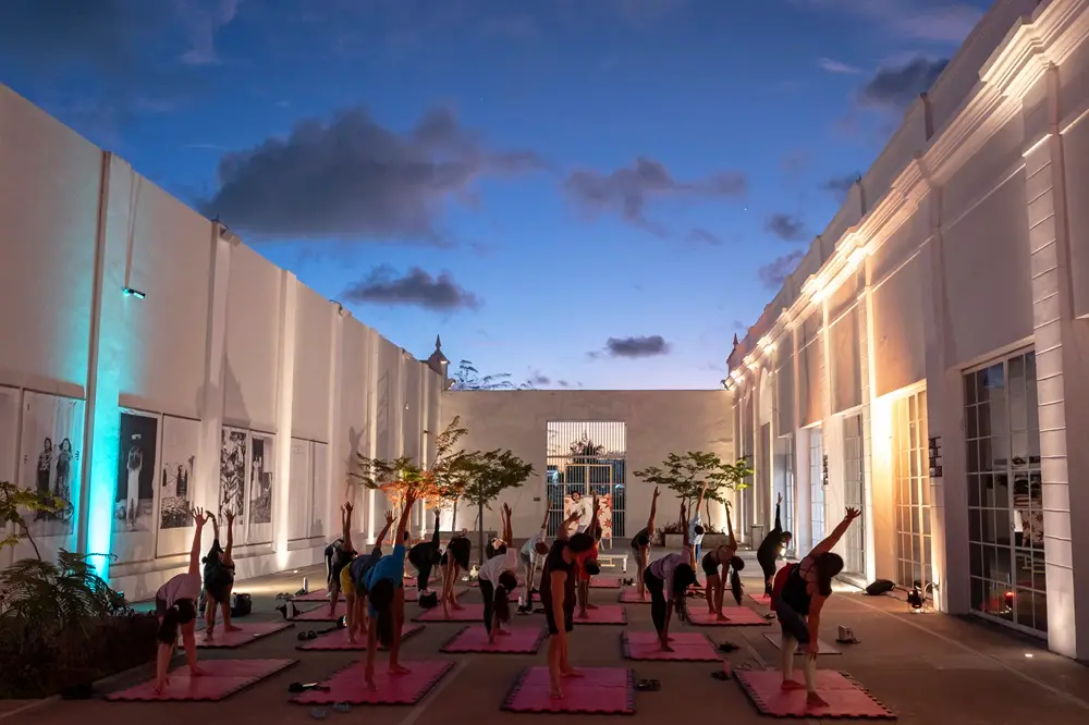 Na imagem, prática de yoga ao pôr do sol na Pinacoteca do Ceará como atividade de férias do equipamento