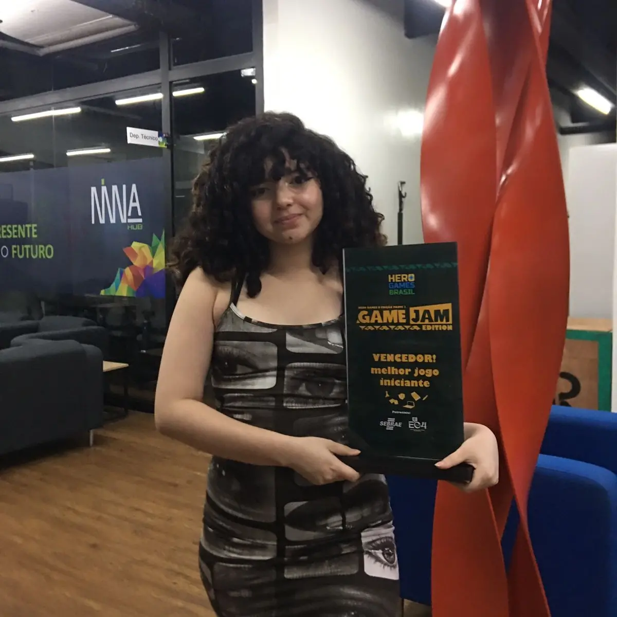 Imagem de Alexandra Silva da Cruz, desenvolvedora de jogos cearense, recebendo reconhecimento em competição de jogos digitais