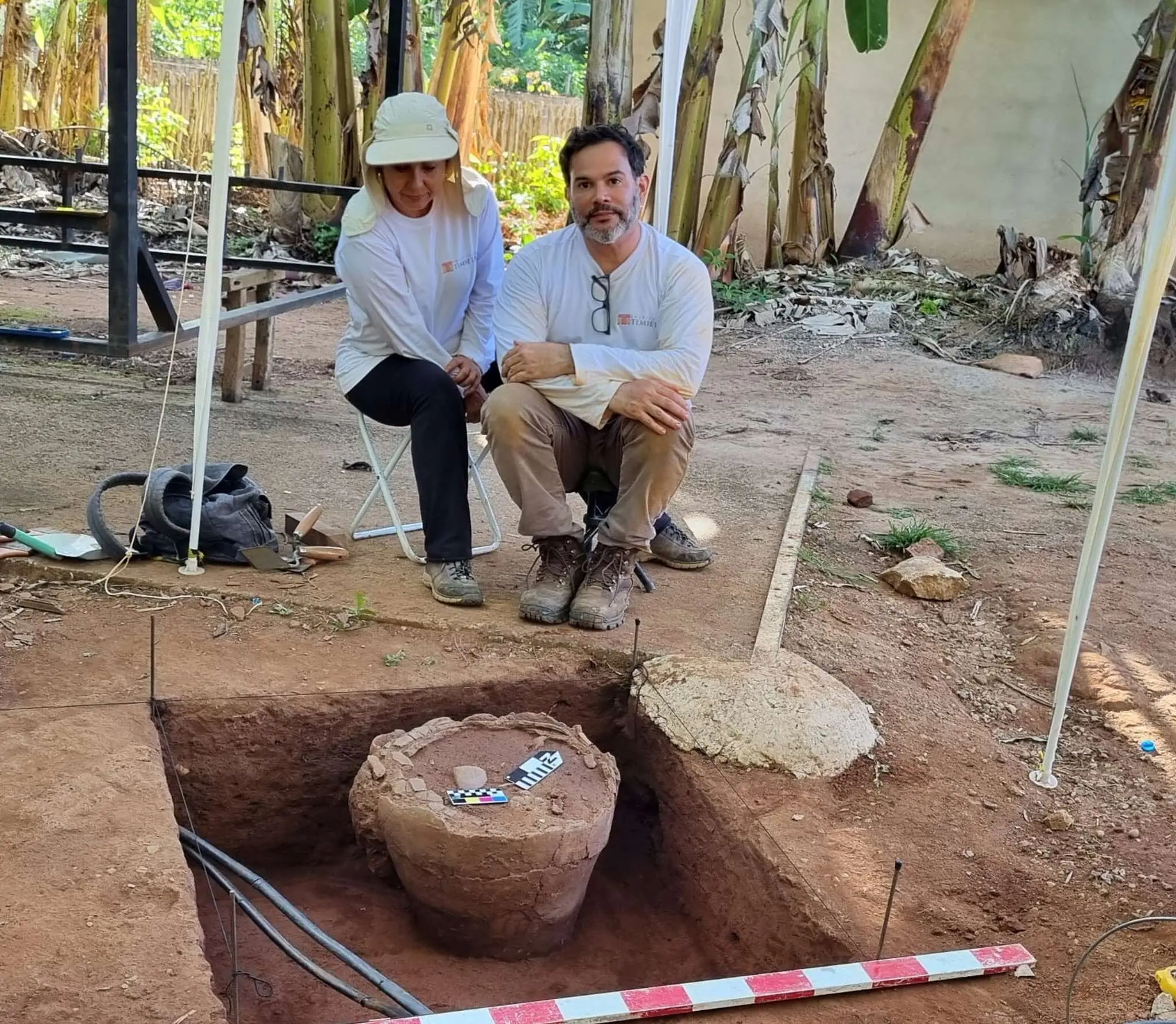 Andrea Lessa e Vinicius Franco próximo a um ponto de escavação