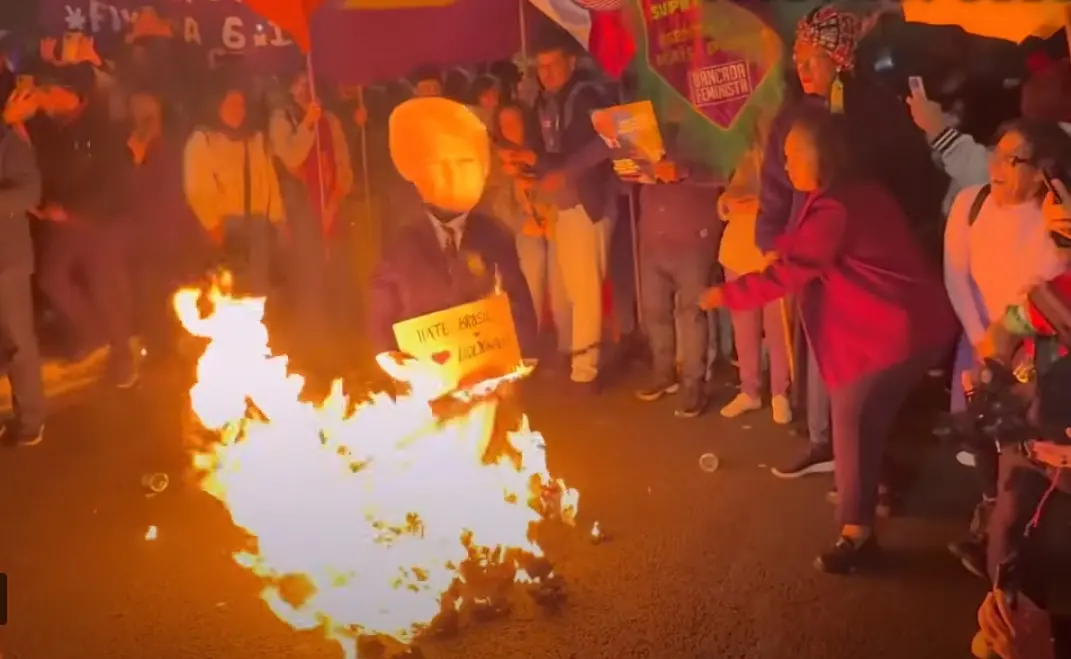 Manifestantes colocando fogo em boneco de Donald Trump em protesto contra taxação dos EUA