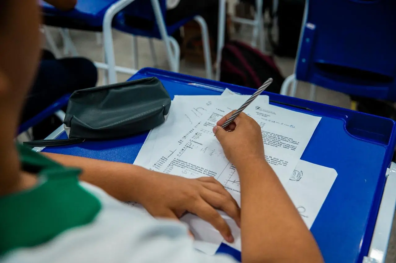 Estudante respondendo questões em aula