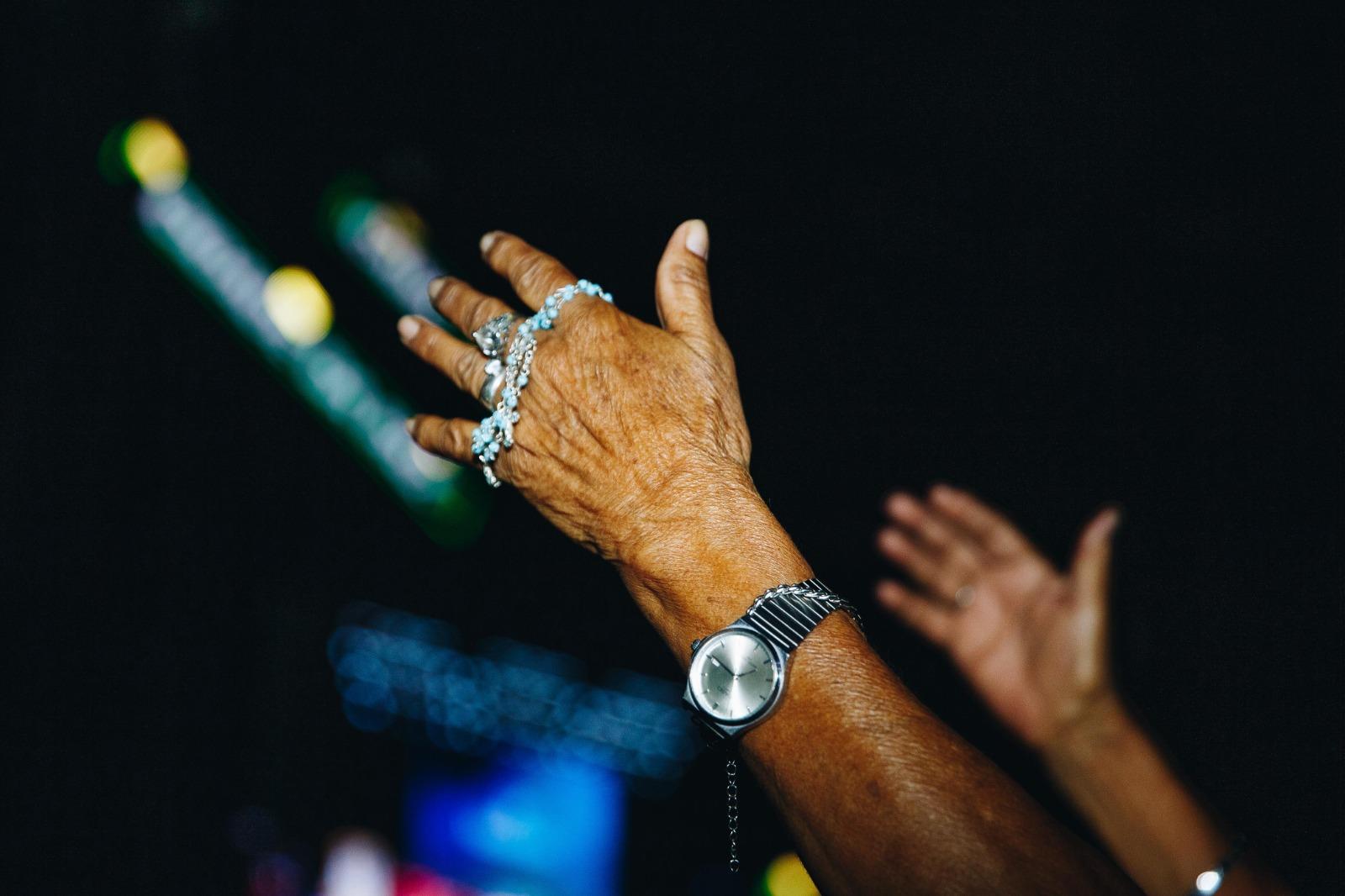 Pessoal segurando o terço enquanto reza