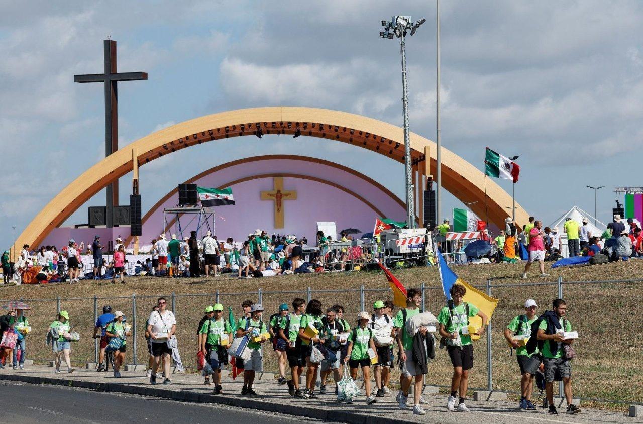 Foto mostra jovens, com bandeiras de vários países, chegando para a vigília do Jubileu, em Roma, Itália