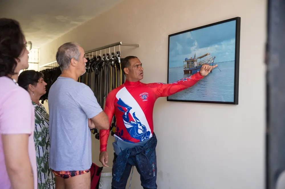 Na imagem, instrutor de mergulho em Fortaleza explica passo a passo para futuro mergulhador