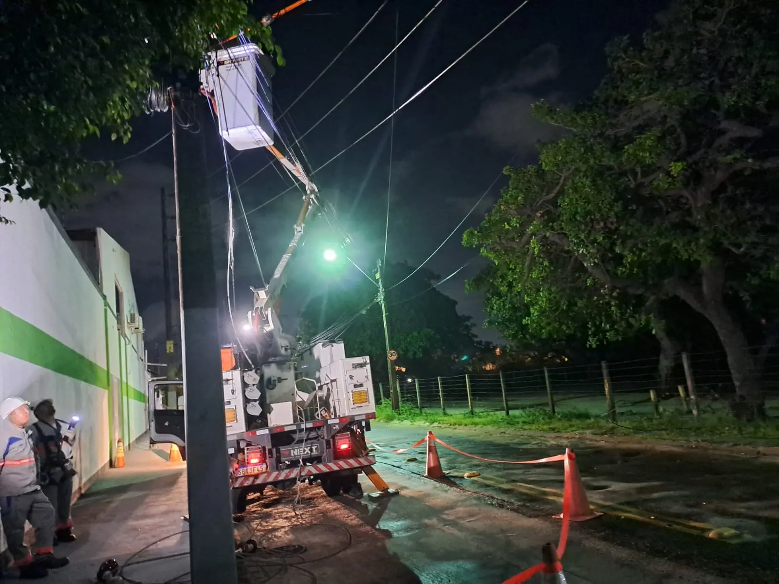Imagem mostra técnicos da Enel realizando reparos na fiação, de madrugada, em razão do furto de fios
