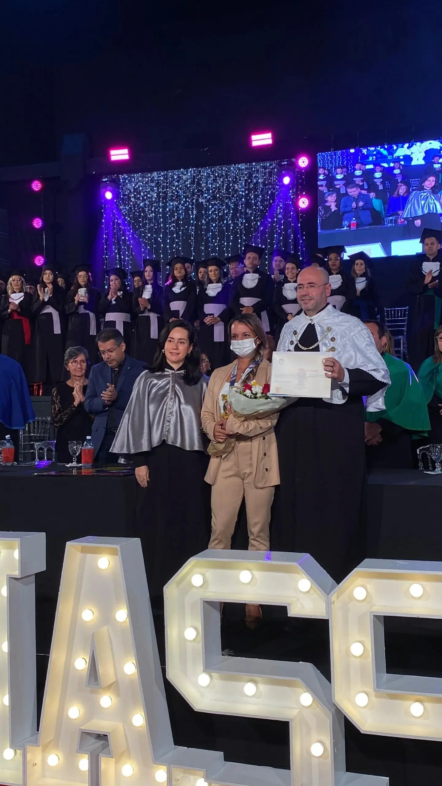 Imagem mostra Juliana Garcia, mulher agredida com 61 socos por ex, sendo homenageada em colação de grau da Uninassau Natal