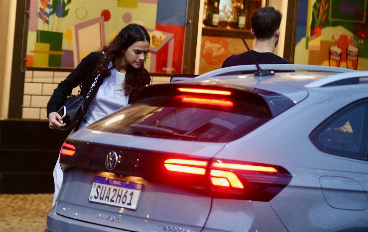 Bruna e João Guilherme ao lado de carro por aplicativo