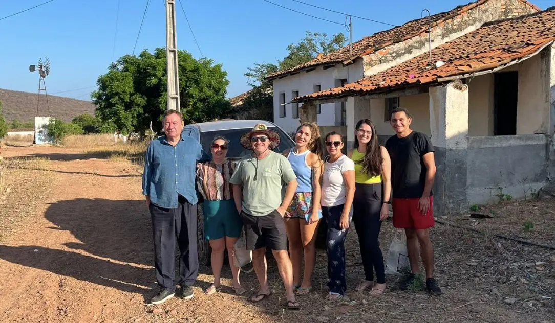 Pessoas posando para foto uma do lado da outra ao lado de casas em Crateús