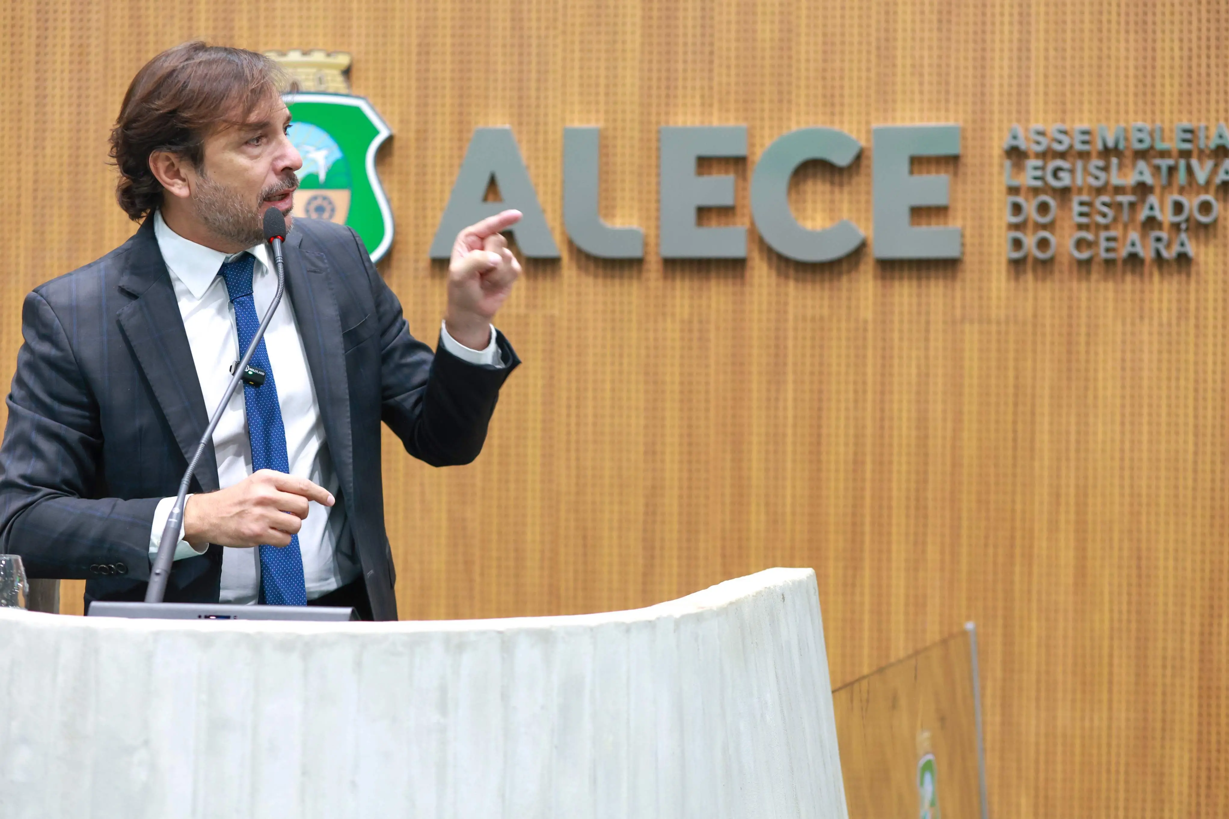 Guilherme Sampaio discursa no plenário e aponta para o lado