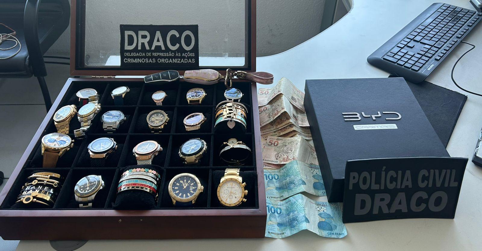 Foto mostra uma coleção de relógios (pelo menos 17 unidades) e pulseiras que foram apreendidos pelos policiais civis, durante o cumprimento dos mandados de busca e apreensão em uma operação
