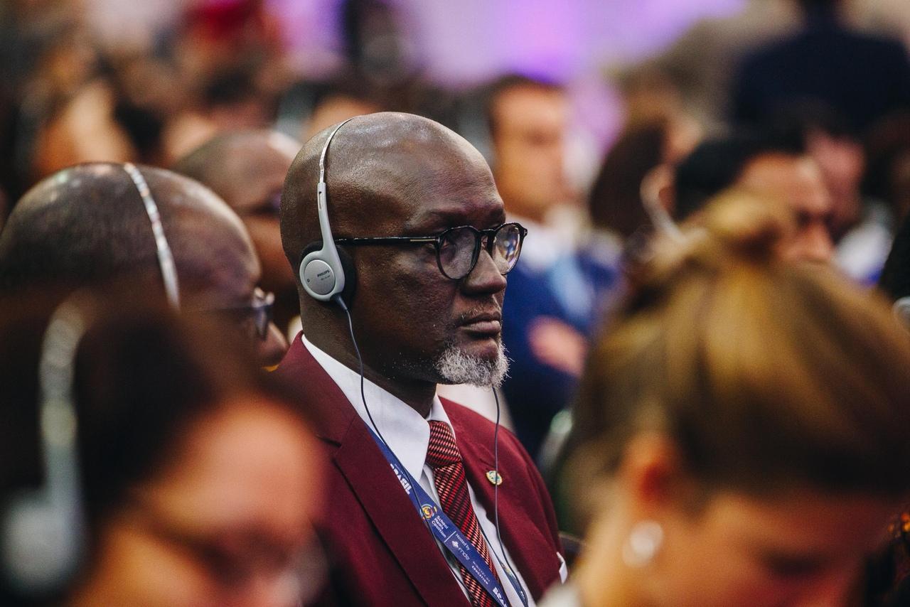 Homem negro assistindo a palestra durante a 2ª Cúpula Global da Coalizão para a Alimentação Escolar