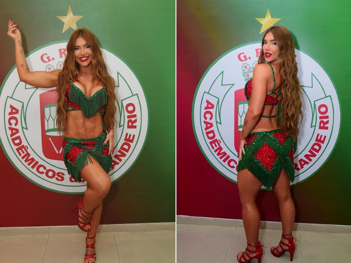 Virginia Fonseca posa em frente ao logo da Grande Rio com fantasia verde e vermelha de Rainha de Bateria.