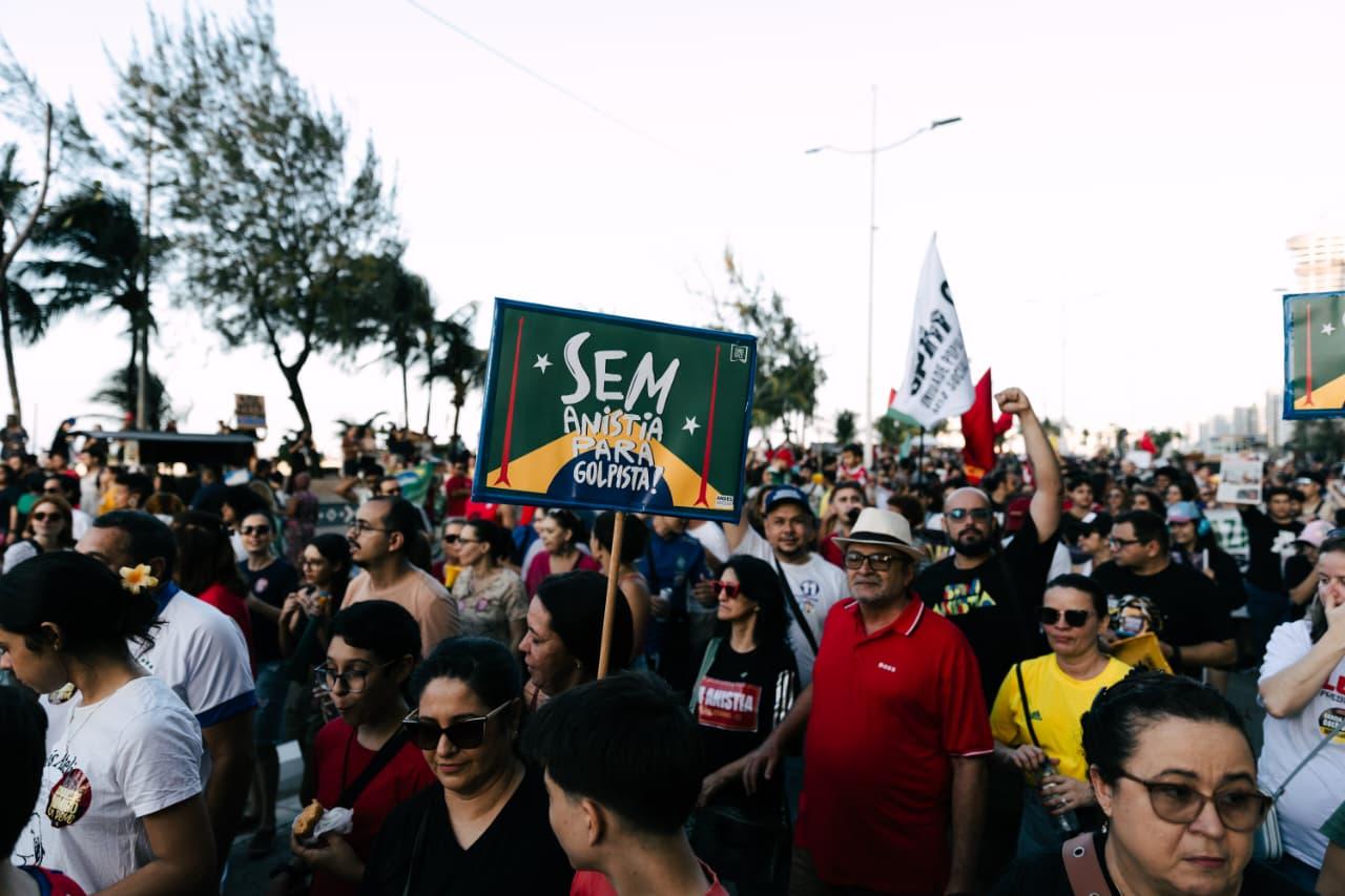 Manifestantes ocupam uma rua em Fortaleza durante protesto contra a PEC da Blindagem. Há ainda cartazes contra a anistia