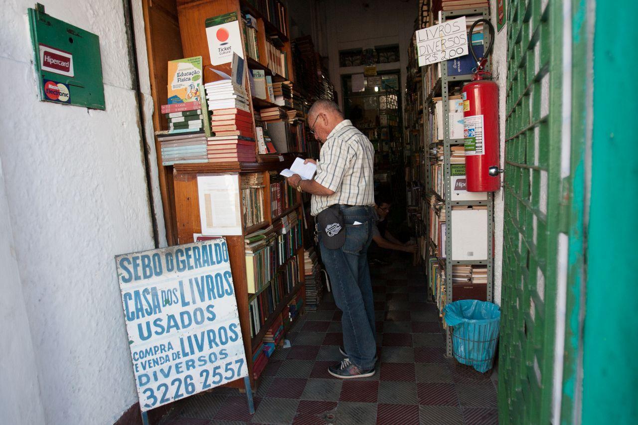 Imagem mostra cliente lendo livro no sebo do Geraldo, no Centro de Fortaleza, em 2015