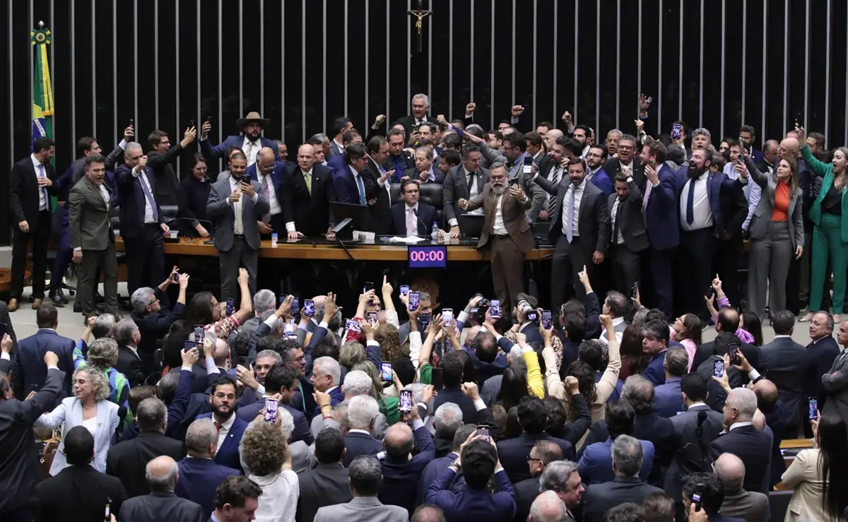 Aglomeração de deputados na mesa diretora da Câmara dos Deputados ao redor do presidente Hugo Motta