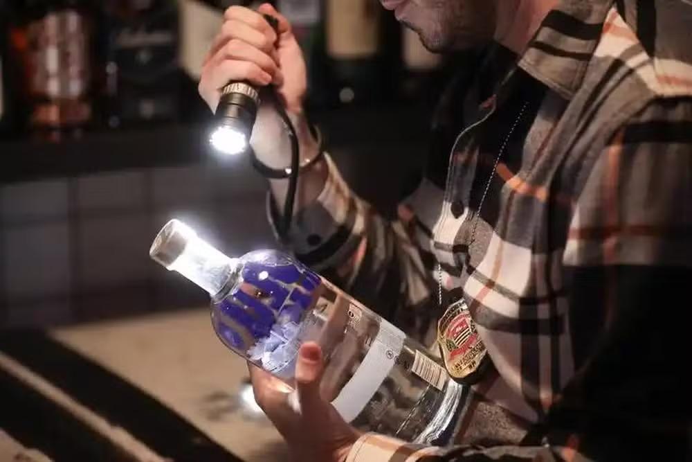 Garrafa de vodka é vistoriada.