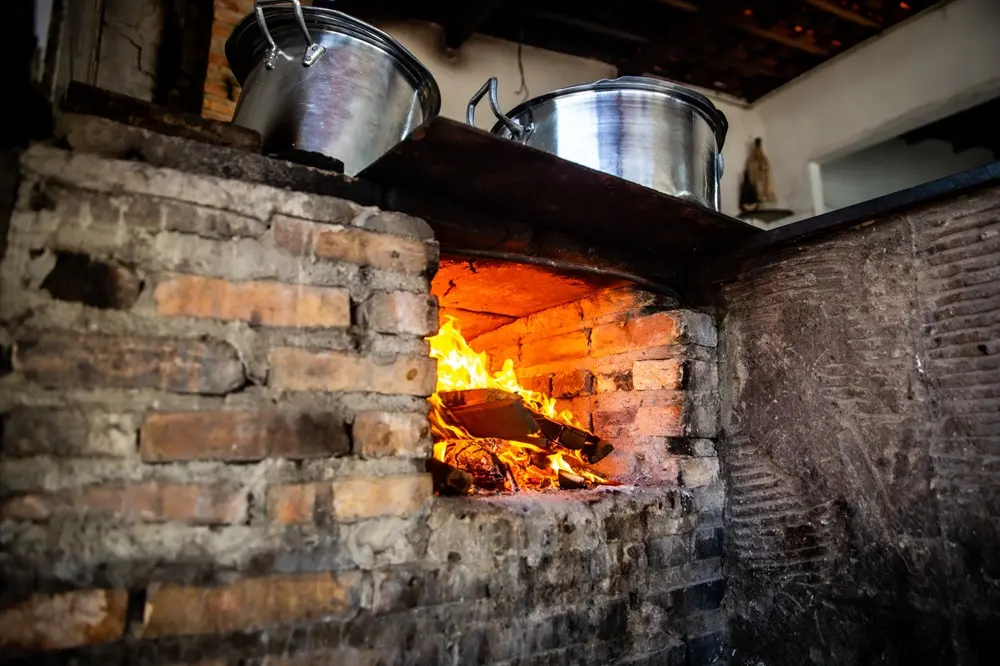 Na imagem, fogão à lenha em funcionamento no Iran da Panelada, estabelecimento de gastronomia regional localizado no bairro Paupina, em Fortaleza