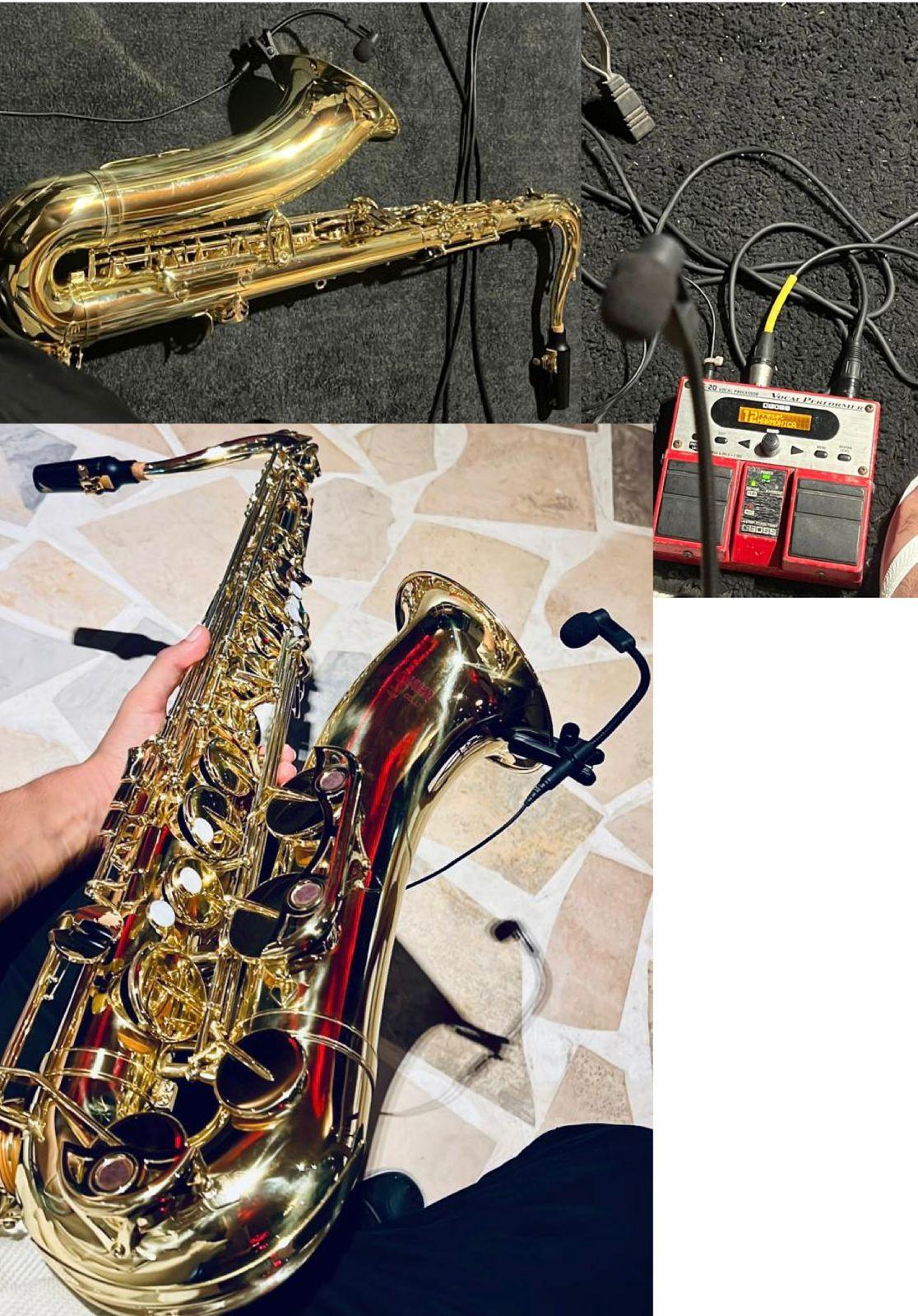 Saxofone dourado em destaque, ligado a um pedal de efeitos e acessórios musicais. Microfone preto ligado por um fio até sua caixa vermelha.