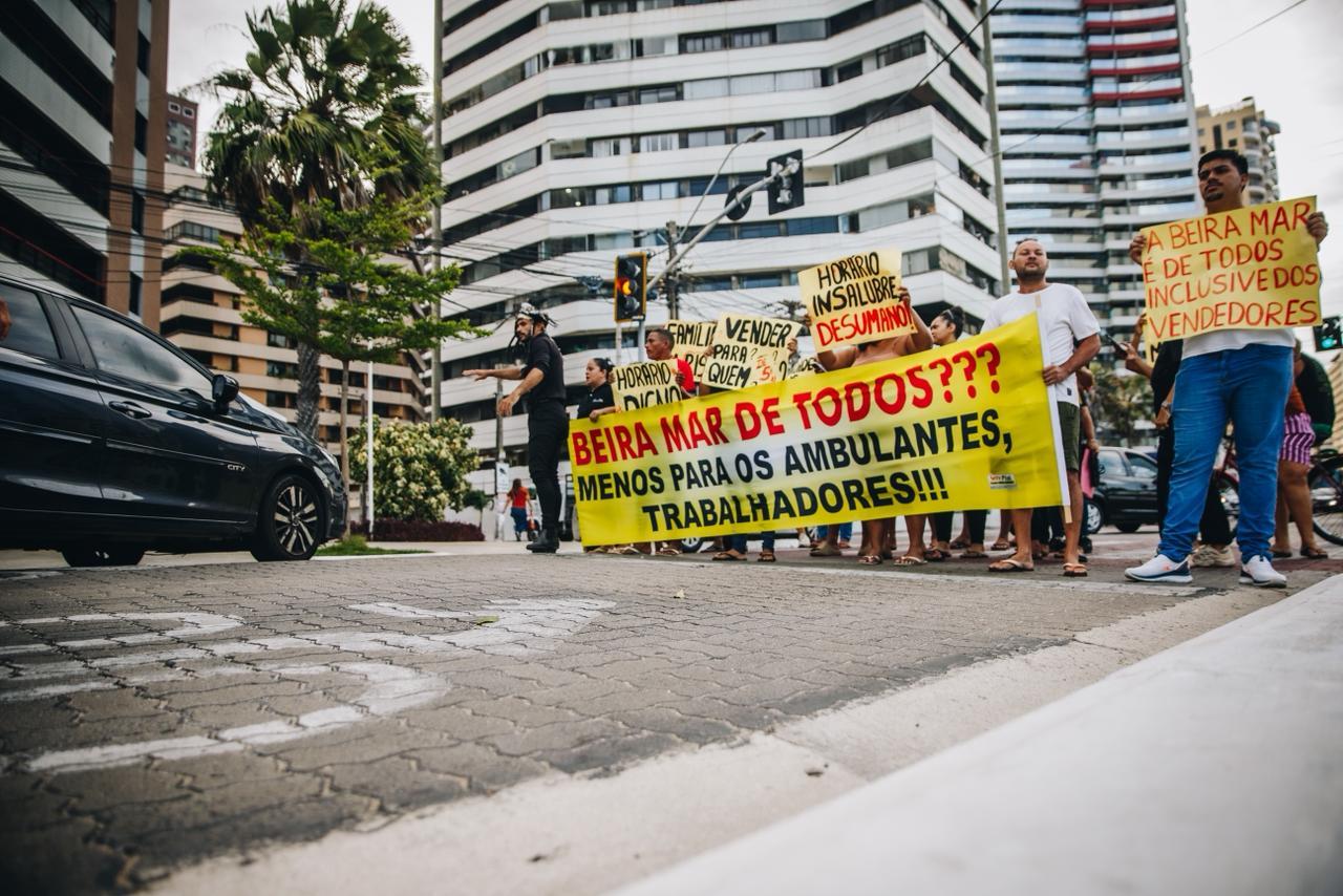 Vendedores se reúnem em protesto com cartazes na Avenida Beira-Mar, em Fortaleza